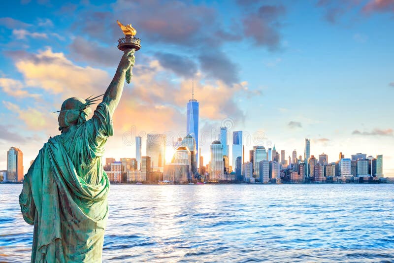 Horizonte de la libertad y de New York City de la estatua en la puesta del sol