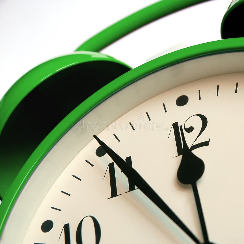 Green retro-style alarm clock showing five minutes to twelve. Green retro-style alarm clock showing five minutes to twelve
