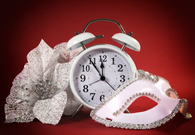 Horloge de bonne année, masque de partie de mascarade et fleurs blanches de fête photographie stock libre de droits Horloge de bonne année, masque de partie de mascarade et fleurs blanches de fête photographie stock libre de droits
