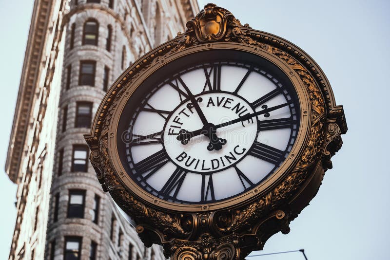 Horloge de bâtiment de Fifth Avenue dans le secteur de fer à repasser photographie stock libre de droits Horloge de bâtiment de Fifth Avenue dans le secteur de fer à repasser photographie stock libre de droits