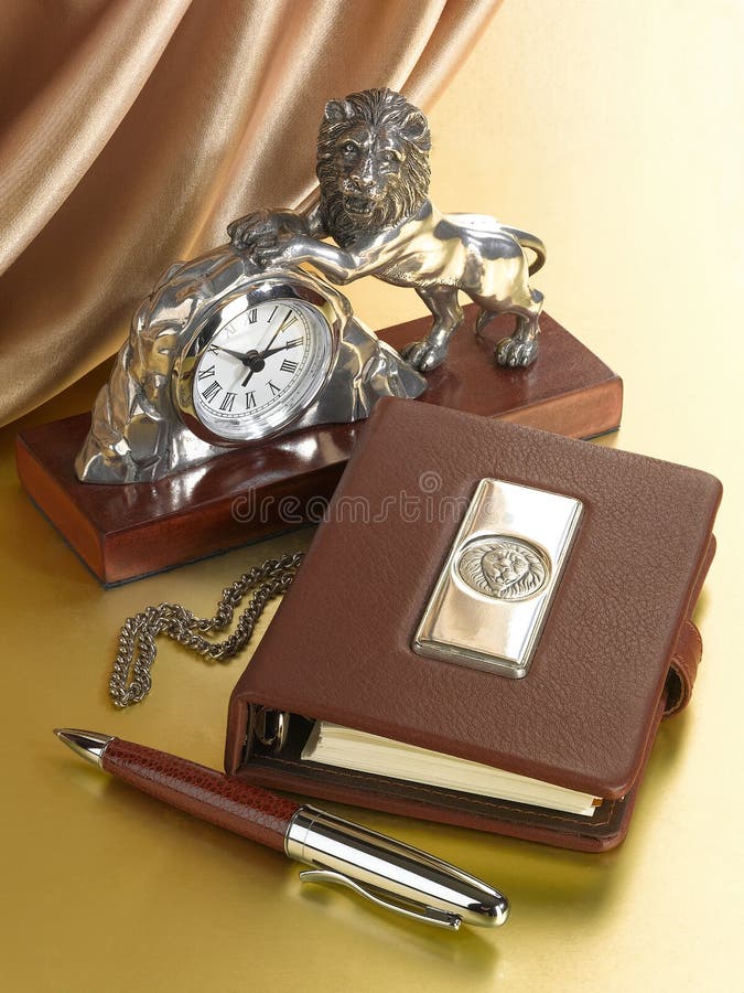 Horloge de Tableau avec une figure d'un lion et d'un journal intime avec l'image d'un lion images libres de droits Horloge de Tableau avec une figure d'un lion et d'un journal intime avec l'image d'un lion images libres de droits