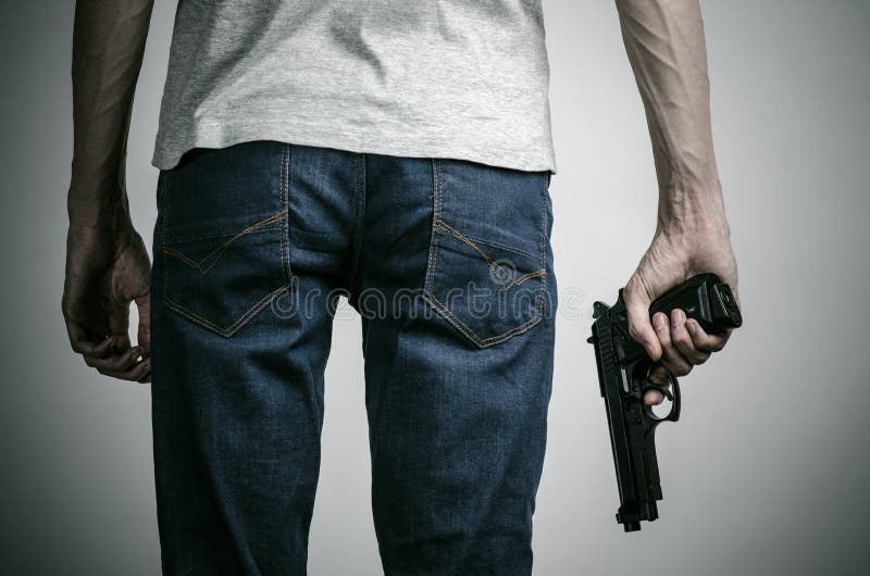 Horror und Feuerwaffenthema: verrückt gemachter Mörder mit einem Gewehr auf einem grauen Hintergrund im Studio