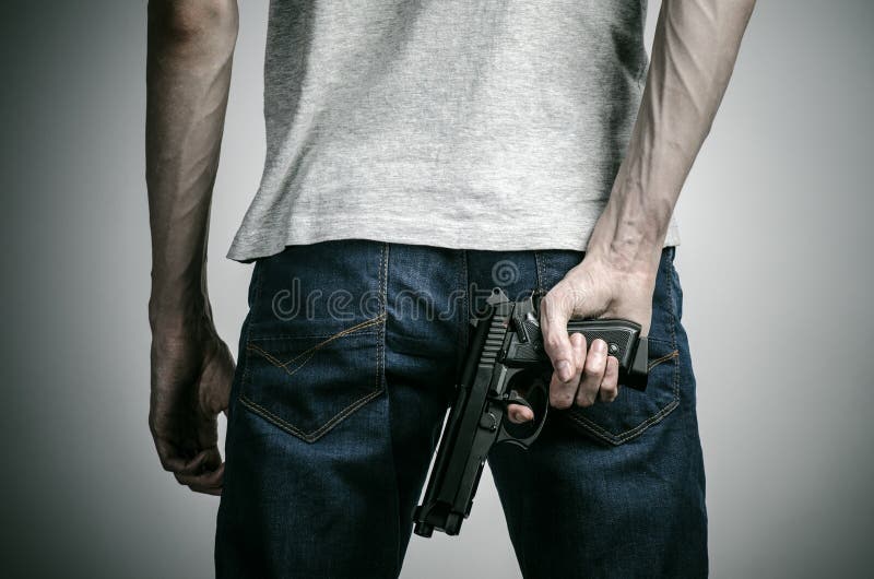 Horror und Feuerwaffenthema: verrückt gemachter Mörder mit einem Gewehr auf einem grauen Hintergrund im Studio