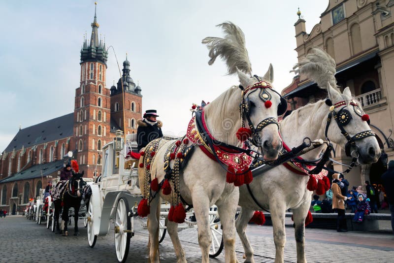 Horse carriages at main square in Krakow in a winter day. KRAKOW, POLAND - Januare 14, 2017: Horse carriages at main square in Krakow in a winter day royalty free stock images Horse carriages at main square in Krakow in a winter day. KRAKOW, POLAND - Januare 14, 2017: Horse carriages at main square in Krakow in a winter day royalty free stock images