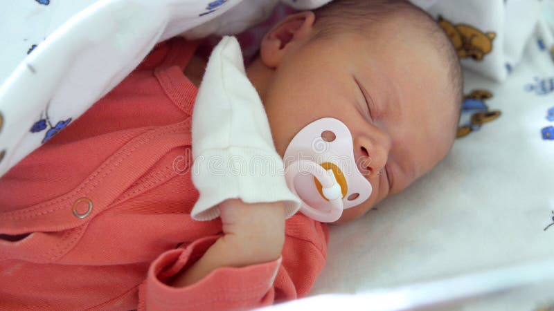 Hospital de maternidade - um bebê recém-nascido está dormindo imagens de stock royalty free Hospital de maternidade - um bebê recém-nascido está dormindo imagens de stock royalty free