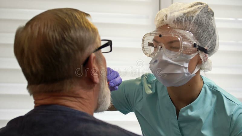 Hospital worker takes patient`s smear to test for coronavirus.