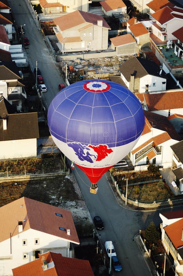 Hot Air Balloon Crossing City Streets Above Buildings