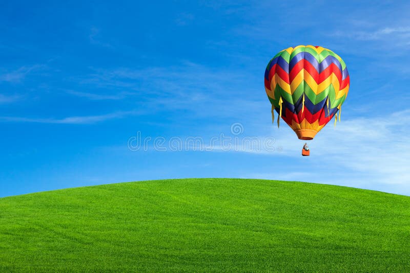 Hot air balloon over green field