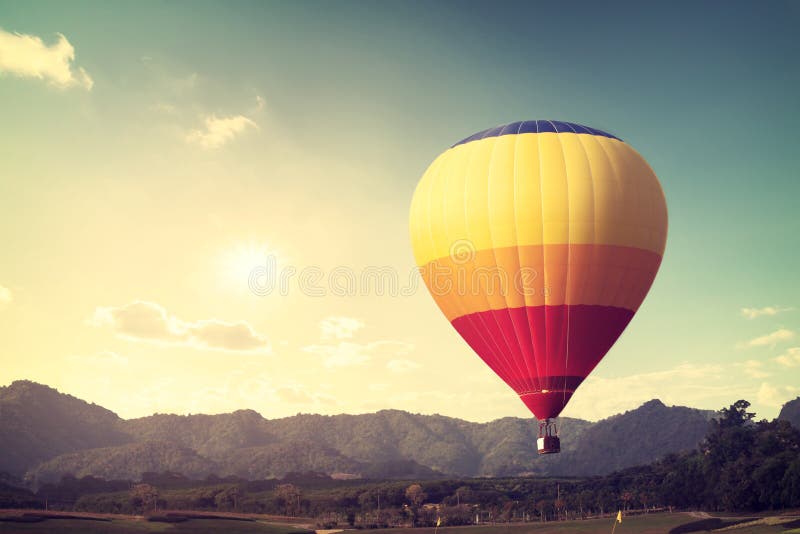 Hot air balloon over mountain, vintage retro filter effect