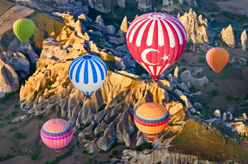 Hot air balloons over mountain landscape in Cappadocia, Turkey