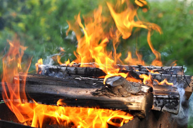 Hot Charcoal Barbecue Grill with Bright Flame on Nature Stock Photo