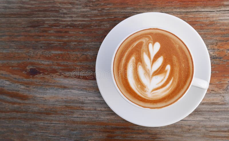 Hot coffee cappuccino latte art top view on wooden background