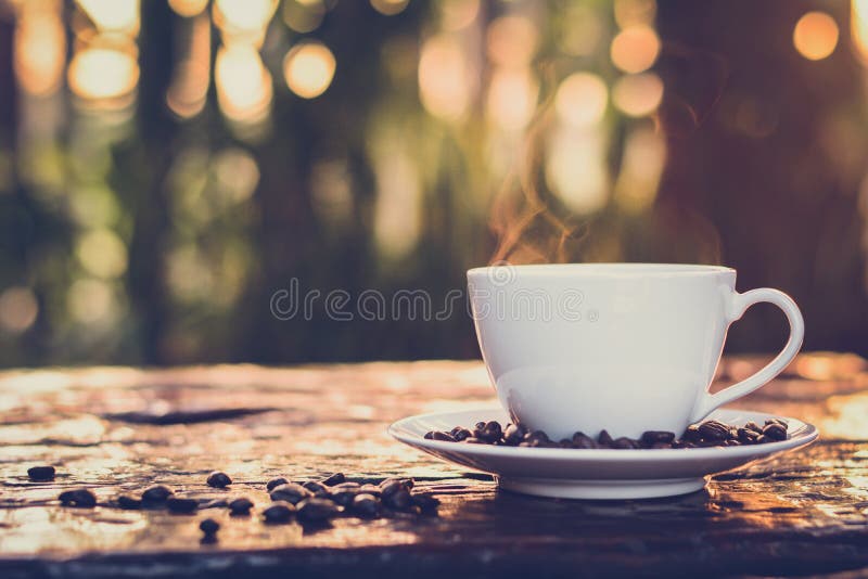 Heißen Kaffee in der Tasse am alten Holz Tisch mit Unschärfe dunkel grün Natur hintergrund im vintage-Stil.