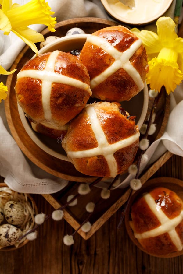 Hot cross buns, freshly baked hot cross buns in a ceramic bowl on a wooden rustic table, top view .