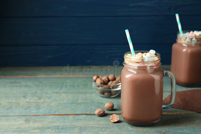 Hot Drink with Marshmallows and Nutmeg Powder on Blue Wooden Table