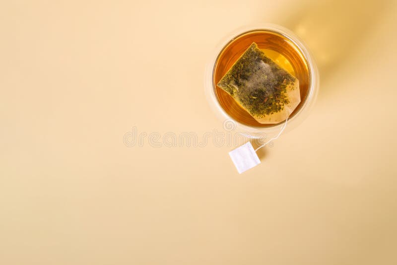 Hot green tea in double walled glass cup with tea bag