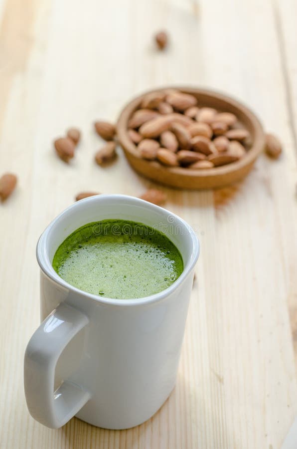 Hot green tea latte in lazy time with almonds nut. royalty free stock photos