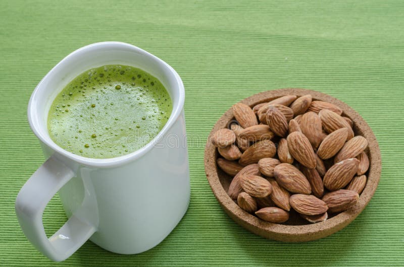Hot green tea latte in lazy time with almonds nut. royalty free stock photography