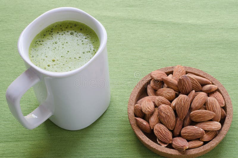 Hot green tea latte in lazy time with almonds nut. royalty free stock photos