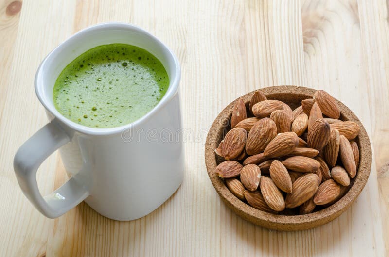 Hot green tea latte in lazy time with almonds nut. stock photo