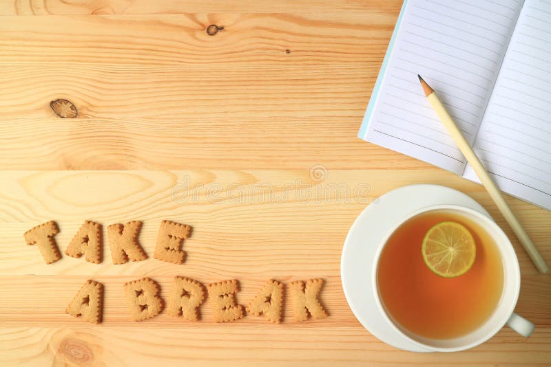 Hot Lemon Tea, Note Papers and Pencil beside with Word TAKE A BREAK Spelling with Cookies