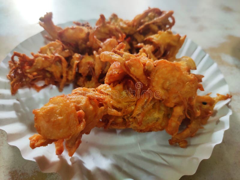 Hot onion bhajjiya bhajiya Indian fast food street food with green pudina chutney on paper plate ready to eat yummy tastey food