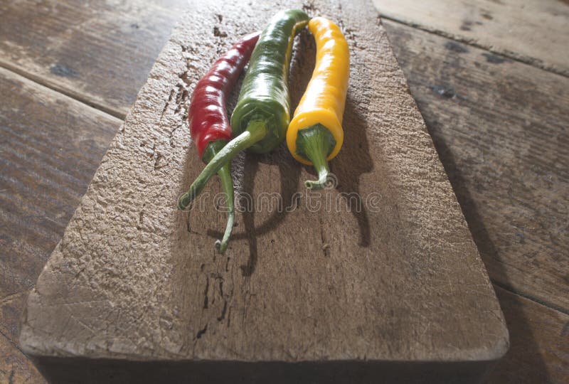 Hot peppers on wooden cutting board stock photography