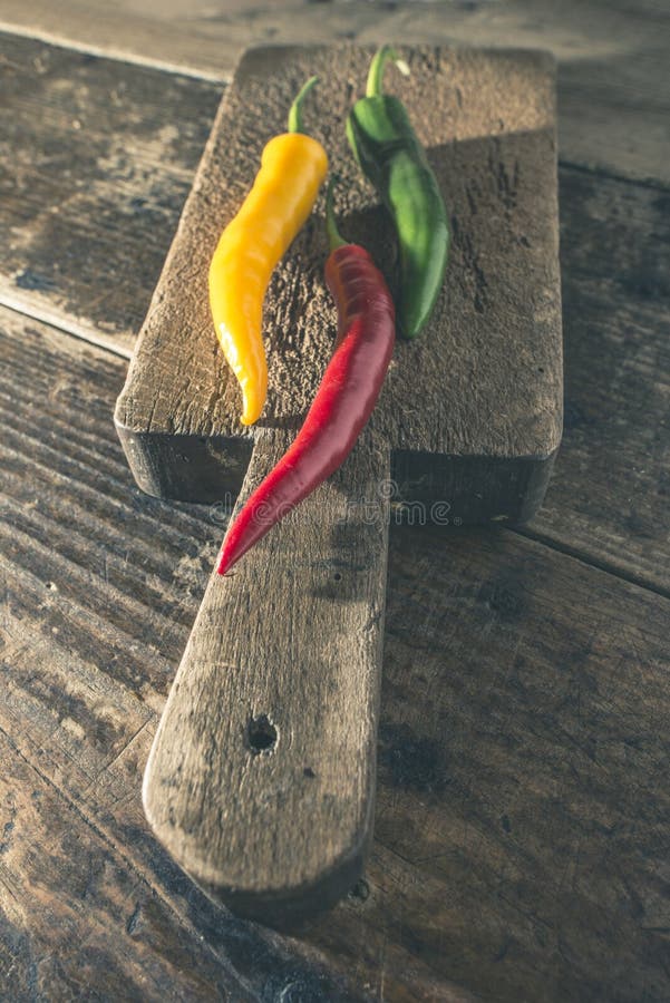 Hot peppers on wooden cutting board stock images