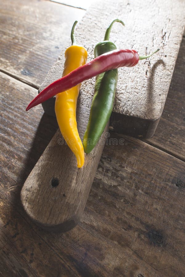 Hot peppers on wooden cutting board stock photography