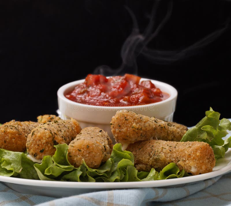 Cheese sticks appetizer on salad with very hot salsa sauce. Smoke on the salsa with a black background. Crispy diet stock images, royalty-free photos and pictures