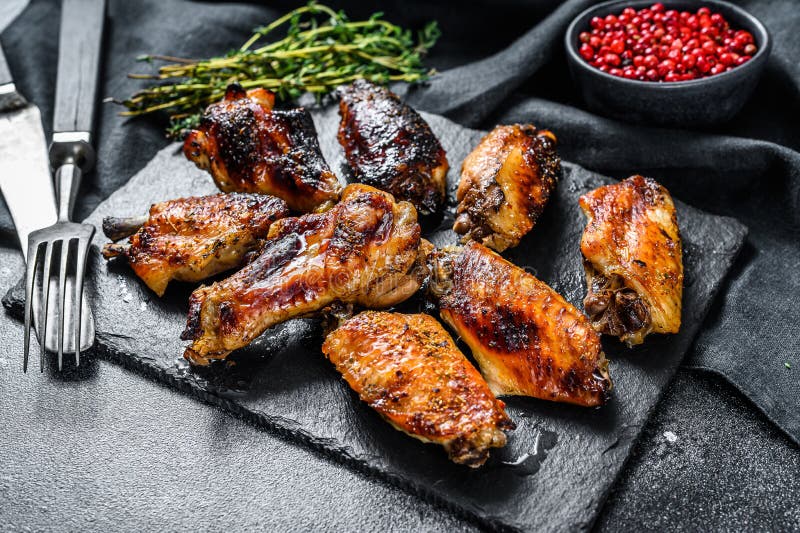 Hot and Spicy Chicken Wings with Hot Sauce. Black Background Stock