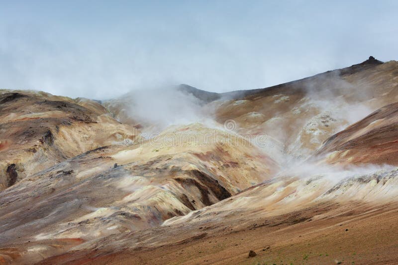 Hot steam raising above colored hills at Hverarond area, Iceland
