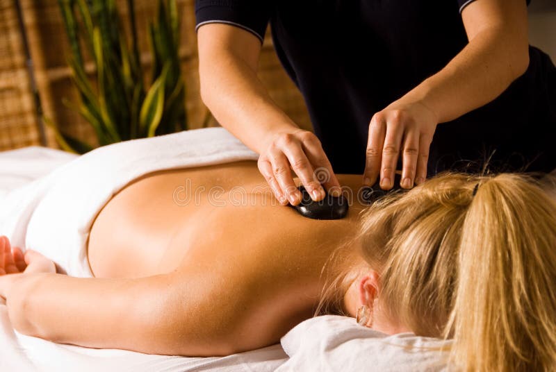 Therapist giving a hot stone massage to woman