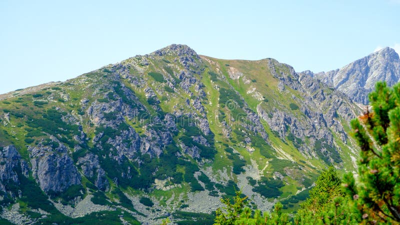 Horúci letný deň so svetlomodrým oparom. Horská krajina s mohutnými skalnatými svahmi Vysokých Tatier na Slovensku