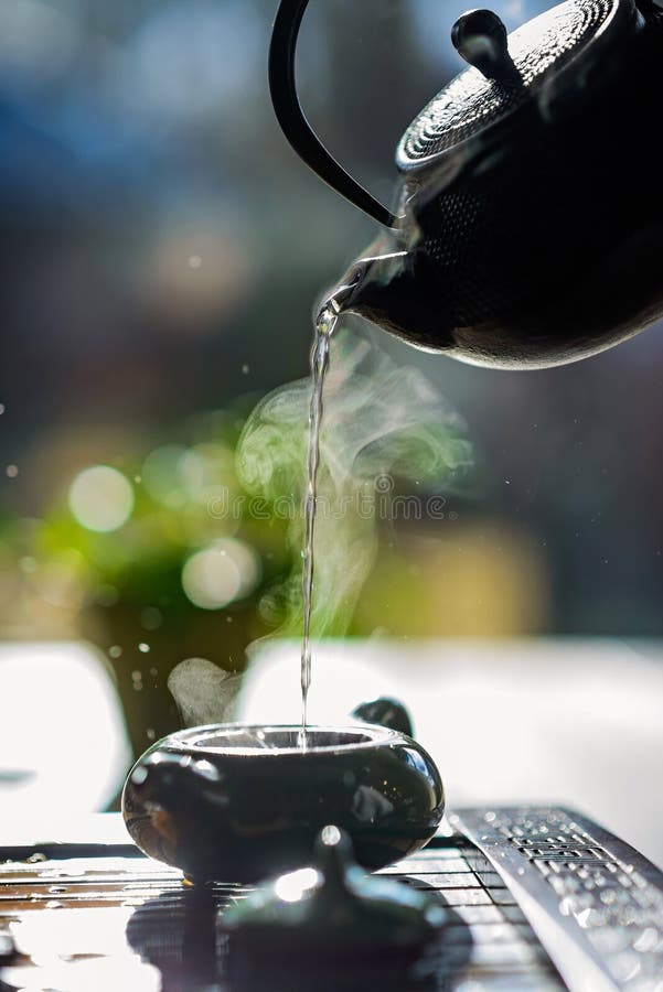 Hot Tea in a Teapot Pours Tea with Steam into a Cup. Tea Ceremony Stock