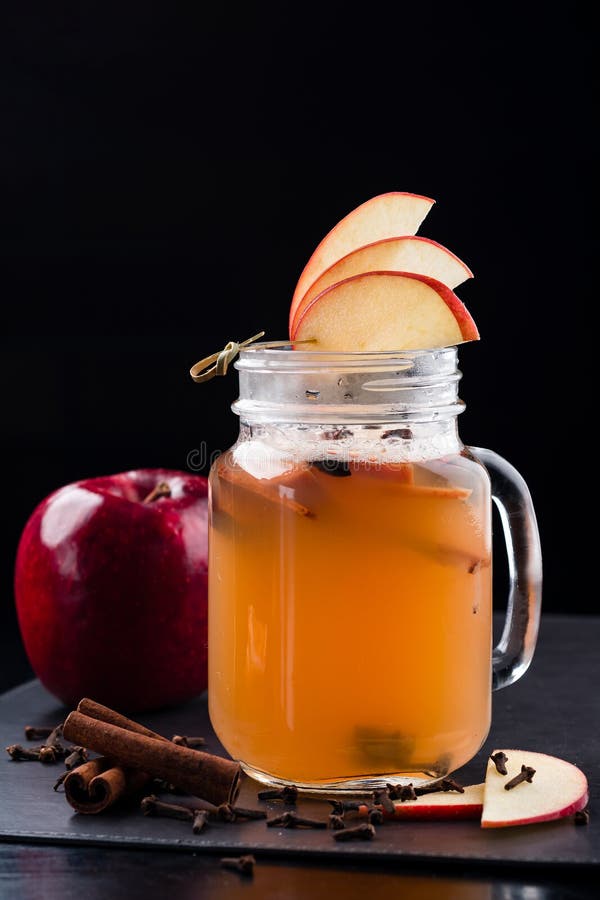 Hot Toddy Cocktail with Apple, Lemon, Rum on Dark Background Stock
