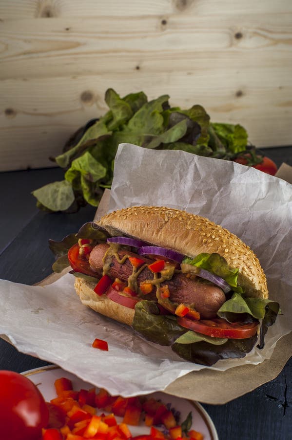 Hotdog com salsicha, os vegetais e alface grelhados imagens de stock