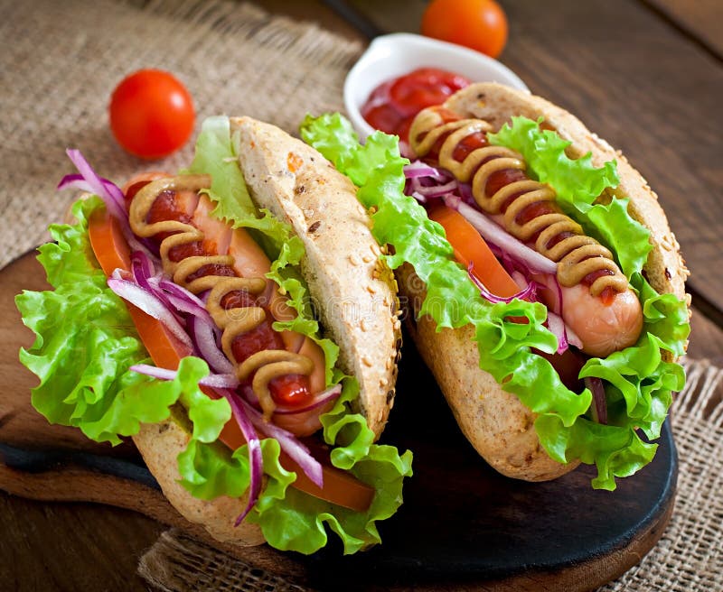 Hotdog met ketchup, mosterd, sla en groenten royalty-vrije stock afbeeldingen Hotdog met ketchup, mosterd, sla en groenten royalty-vrije stock afbeeldingen