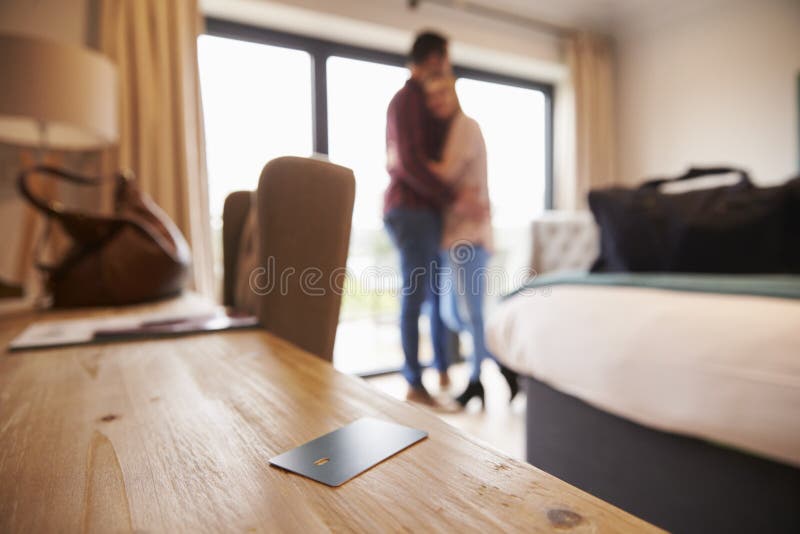 Hotel Room Key With Romantic Couple In Background