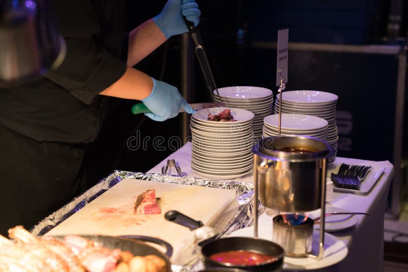 Hotelchef-kok die geroosterd rundvlees krabbetje met lange mes en FO snijden royalty-vrije stock foto Hotelchef-kok die geroosterd rundvlees krabbetje met lange mes en FO snijden royalty-vrije stock foto