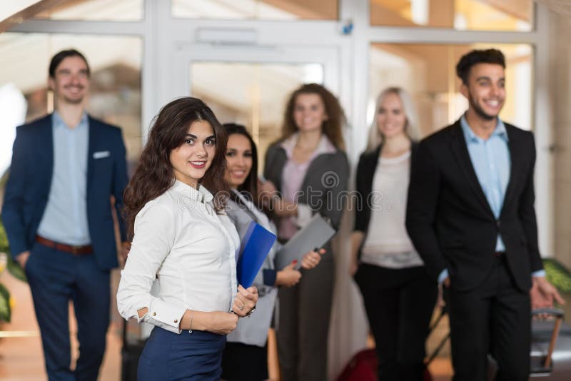 Hotelladministratören Welcome Business People i lobbyen, gäster för grupp för blandningloppBusinesspeople ankommer royaltyfri fotografi