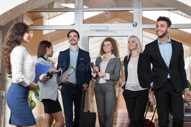 Hotelladministratören Welcome Business People i lobbyen, gäster för grupp för blandningloppBusinesspeople ankommer arkivbilder