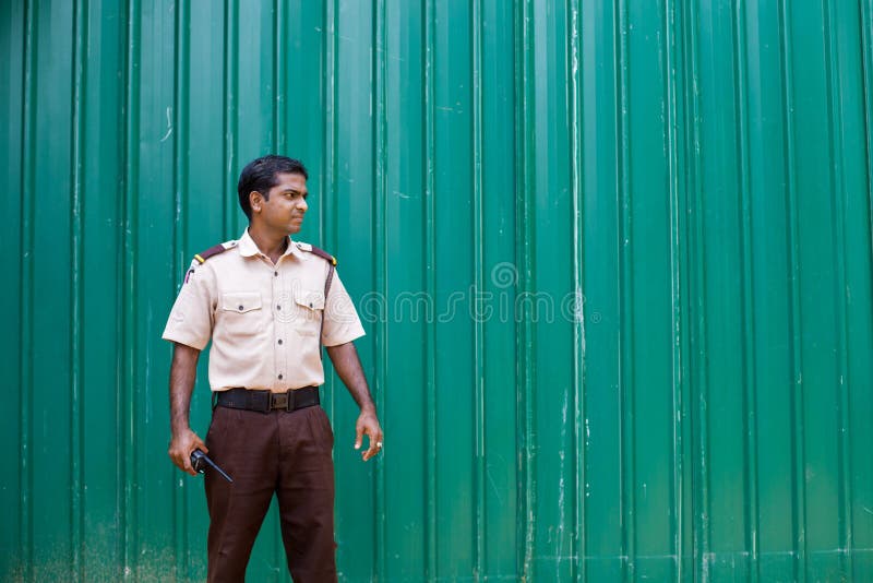 Hotellordningsvakt i Sri Lanka mot ett grönt staket arkivfoto Hotellordningsvakt i Sri Lanka mot ett grönt staket arkivfoto