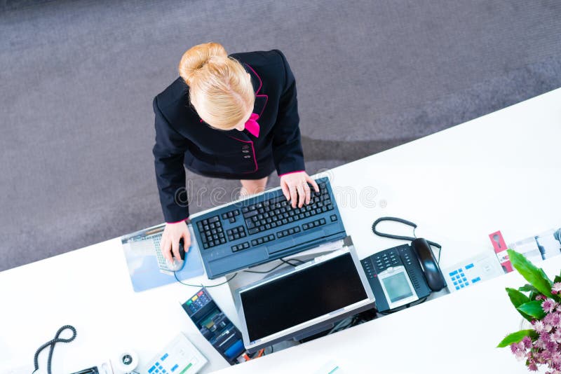 Hotellreceptionist som arbetar på det främre kontoret royaltyfri fotografi Hotellreceptionist som arbetar på det främre kontoret royaltyfri fotografi