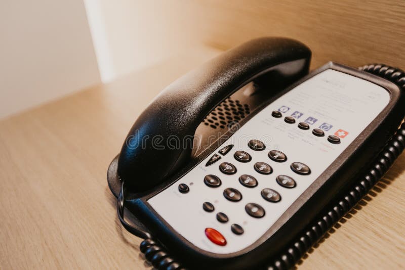 Hotellrumtelefon på ett träskrivbord royaltyfri fotografi Hotellrumtelefon på ett träskrivbord royaltyfri fotografi