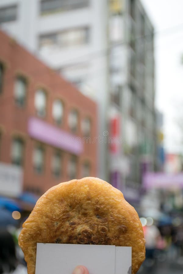 Hotteok or sweet Korean pancake with town in background. stock photo Hotteok or sweet Korean pancake with town in background. stock photo