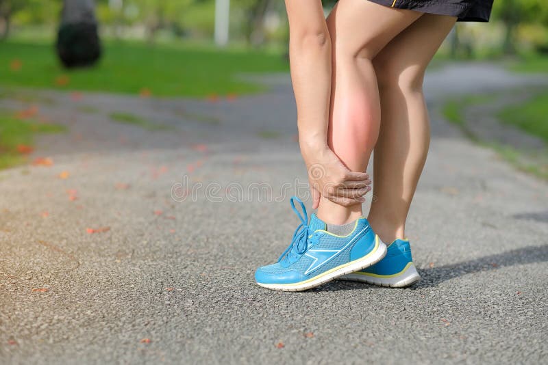 Young fitness woman holding his sports leg injury, muscle painful during training. Asian runner having calf ache and problem after running and exercise outside in summer. Young fitness woman holding his sports leg injury, muscle painful during training. Asian runner having calf ache and problem after running and exercise outside in summer