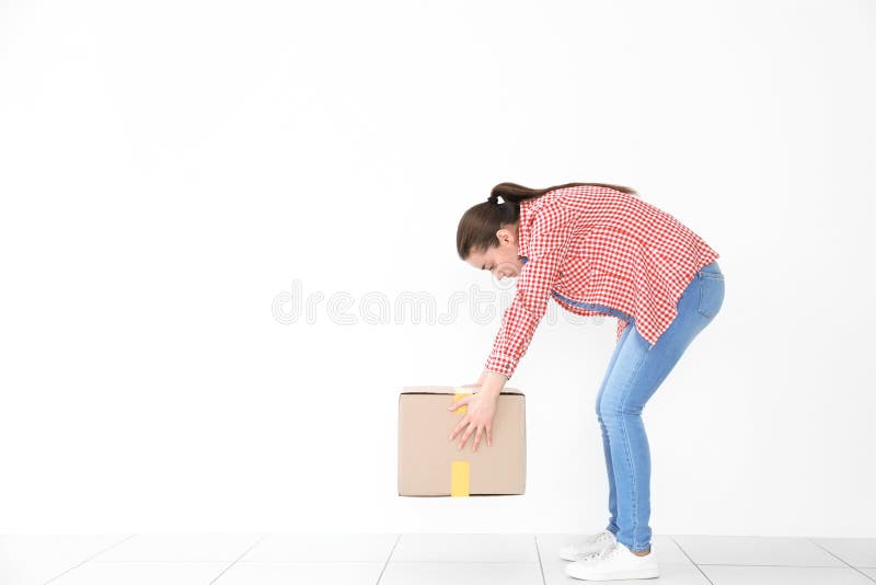Houdingsconcept Jonge vrouw die zware kartondoos opheffen stock afbeeldingen Houdingsconcept Jonge vrouw die zware kartondoos opheffen stock afbeeldingen