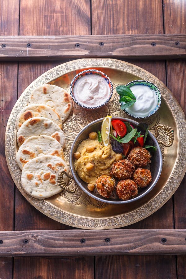 Houmous, falafel, salade et pain pita dans une casserole de cuivre photo stock Houmous, falafel, salade et pain pita dans une casserole de cuivre photo stock