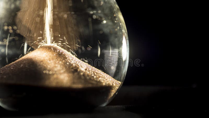 Hourglass close-up on a black background stock photography